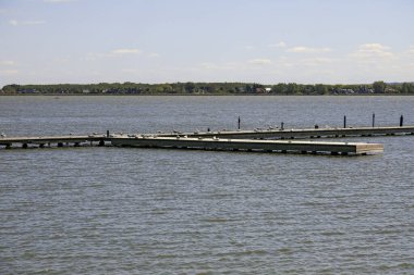 Polonya 'da bir tatil beldesi olan Mielno' daki Jamno Gölü 'ndeki iskele boş. Orada ne tekne ne de insan var. Orada sadece martılar oturur..