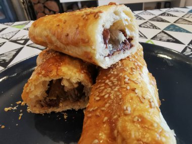 Lezzetli Flaky Sausage Rolls on Blue Plate with Susam Seeds