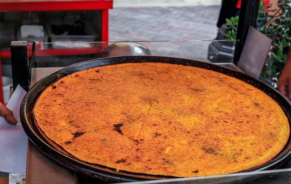 stock image Socca, traditional thin chickpea flour pancake or crepe cooked for sale at farmers market in Cours Saleya in Vieille Ville or Old Town in Nice, France