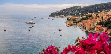 Fransa 'nın güney kesimindeki Villefranche sur Mer manzaralı Fransız Riviera sahili manzarası begonvil çiçekleri tarafından çerçevelenmiştir.