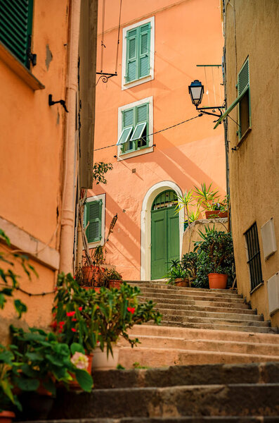 Traditional old terracotta houses on a narrow street in the Old Town of Villefranche sur Mer on the French Riviera, South of France