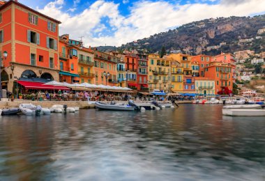 Seaside promenade with colorful houses and boats on the Mediterranean Sea in Villefranche sur Mer Old Town on the French Riviera, South of France clipart