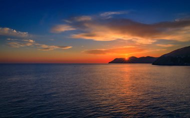 Akdeniz 'de gün batımı manzarası su üzerindeki uçurumlar ve İtalya' nın Cinque Terre kentindeki eski Manarola kasabasında batan güneş.
