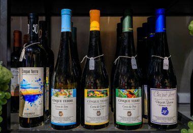 Manarola, İtalya - 1 Haziran 2022: Geleneksel Cinque Terre vendemmia ve sassarini beyaz şarabı sergilenmekte, yerel eski kasaba hediyelik eşya dükkanı