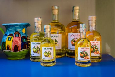 Manarola, İtalya - 2 Haziran 2022: Geleneksel Cinque Terre limoncino ve arancino şişeleri, limon ve portakal likörü eski bir hediyelik eşya dükkanında satılıyor
