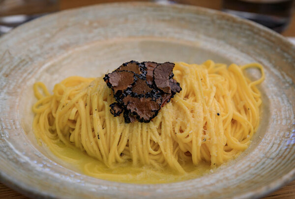 Fresh pasta with truffle sauce, topped with shaved black truffles and shaved parmesan cheese at an Italian restaurant, Centro Storico, Florence, Italy