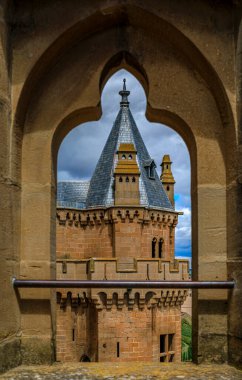 Olite, Spain - June 23, 2021: Gothic tower of the palace of the Kings of Navarre or Royal Palace of Olite in Navarra seen through an ornate embrasure