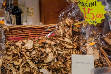 Dried sliced porcini mushrooms for sale in a wicker basket with a description label at a shop in Central Market Mercato Centrale in Florence, Italy