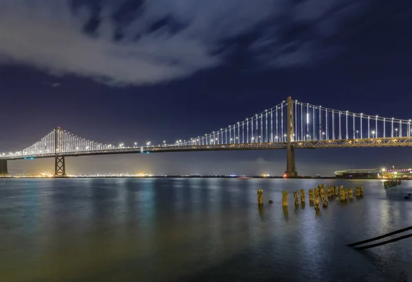 San Francisco Bay Bridge Luzes Noite Refletindo Água Baía Longa — Fotografia de Stock