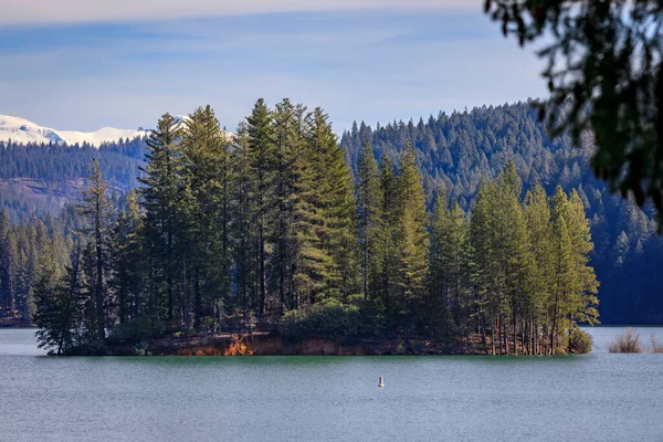 stock image Jenkinson Lake in Sly Park and snow capped Sierra Nevada Mountains in the background in the Northern California in the winter