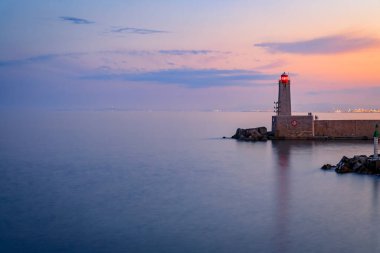 Stunning view of the Mediterranean Sea with the lighthouse in the harbor at sunset in Nice, South of France or the French Riviera