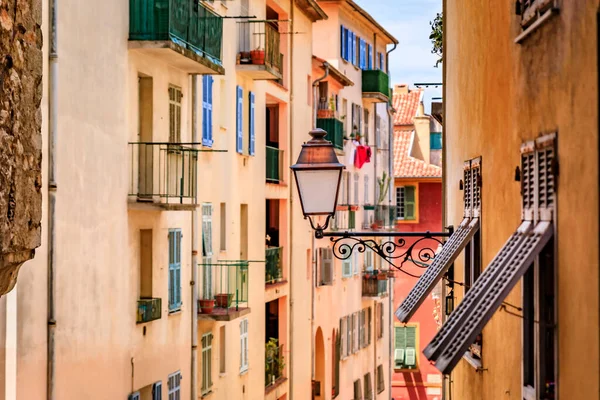 Facades of old traditional Mediterranean houses with wooden shutters and street lights in the streets of Old Town Vielle Ville, Nice, South of France