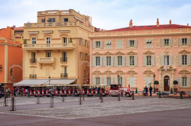 Monaco Ville, Monako - 13 Ekim 2013: Palace Meydanı 'ndaki süslü evlerin ve Monako' nun kırmızı-beyaz raysız turist treninin görüntüsü
