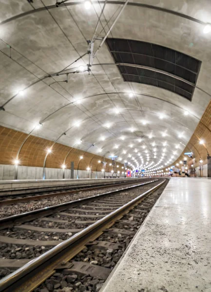 Train tracks disappearing into the tunnel and lights at the Monte Carlo, Monaco underground train station in Cote d Azur