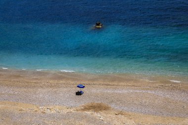 Akdeniz 'in turkuaz suyuna ve Fransa' nın güneyindeki Roquebrune Cap Martin 'de Monako yakınlarında bir çakıl taşı plajına bakın.