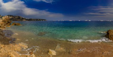 Akdeniz 'in turkuaz suyuna panoramik manzara ve Fransa' nın güneyinde, Roquebrune Cap Martin 'de kayalık bir plaj.