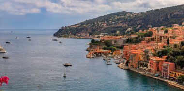 Bougainvillea çiçekleri Fransa 'nın güneyindeki Villefranche sur Mer' de Fransız Riviera kıyılarının hava panoramik manzarasını çerçeveliyor.