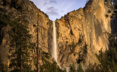 Yosemite Vadisi ve BridalVeil 'in günbatımında Kaliforniya, Sierra Nevada' daki Yosemite Ulusal Parkı 'ndaki manzarası.