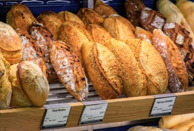 Fransa 'nın güneyindeki Vieil Antibes veya eski kasabadaki bir fırında sergilenmekte olan taze pişmiş Fransız levain ekmeği somunları