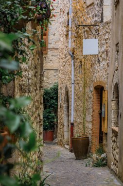 Fransa 'nın güneyindeki Saint Paul de Vence, Fransız Rivierası' ndaki dar bir sokakta geleneksel taş evler.