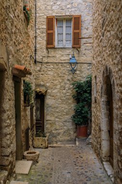Fransa 'nın güneyindeki Saint Paul de Vence, Fransız Rivierası' ndaki dar bir sokakta geleneksel taş evler.