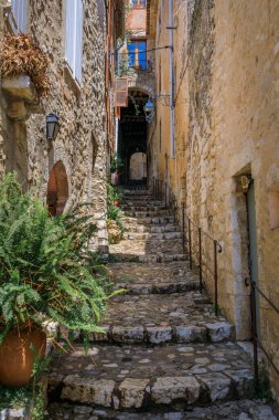Fransa 'nın güneyindeki Fransız Rivierası, Saint Paul de Vence kasabasında basamakları olan dik dar bir sokakta geleneksel taş evler.