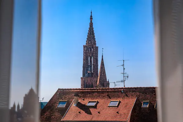 法国阿尔萨斯斯特拉斯堡圣母院和新圣殿伊格里斯教堂的大岛城天际线通过窗户 瓦片屋顶和塔尖 — 图库照片