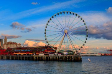 Şehir merkezindeki gökdelenli gökdelenler ve Büyük Tekerlek manzaralı Puget Sound Seattle, Washington, ABD 'de gün batımında.