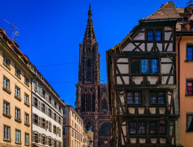 Ön cephe ve Notre Dame Katedrali 'nin kulesi ve Strasbourg, Alsace, Fransa' da sarp çatıları olan geleneksel yarı ahşap evler.