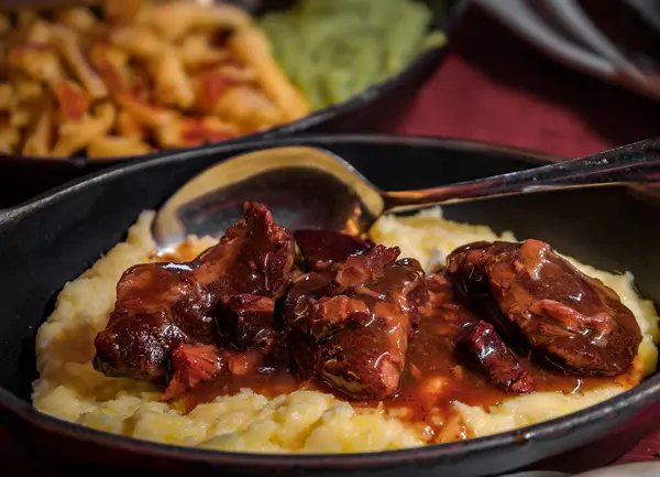 Traditional Alsatian braised pork cheeks in red wine sauce and on a bed of mashed potato puree at a winstub restaurant Strasbourg, Alsace, France