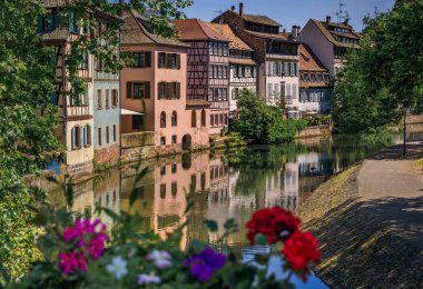 Strasbourg, Alsace, Fransa 'nın pitoresk Fransa bölgesindeki kanallar boyunca çiçeklerle süslenmiş geleneksel yarı ahşap evler.
