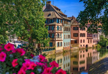 Strasbourg, Alsace, Fransa 'nın pitoresk Fransa bölgesindeki kanallar boyunca çiçeklerle süslenmiş geleneksel yarı ahşap evler.