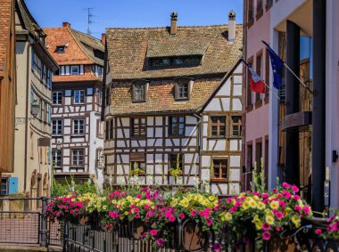 Strasbourg, Alsace, Fransa 'nın pitoresk Fransa bölgesindeki kanallar boyunca çiçeklerle süslenmiş geleneksel yarı ahşap evler.