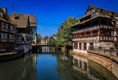 Strasbourg, Alsace, Fransa 'nın pitoresk Fransa bölgesindeki kanallar boyunca çiçeklerle süslenmiş geleneksel yarı ahşap evler.