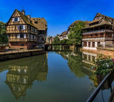 Strasbourg, Alsace, Fransa 'nın pitoresk Fransa bölgesindeki kanallar boyunca çiçeklerle süslenmiş geleneksel yarı ahşap evler.