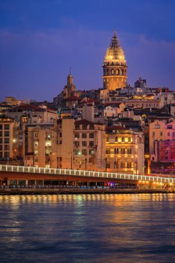 Türkiye 'nin İstanbul kentindeki Galata Kulesi' nin mavi saatinde Galata Köprüsü yakınlarındaki İstanbul Boğazı 'ndaki Karaköy bölgesinin gün doğumu manzarası