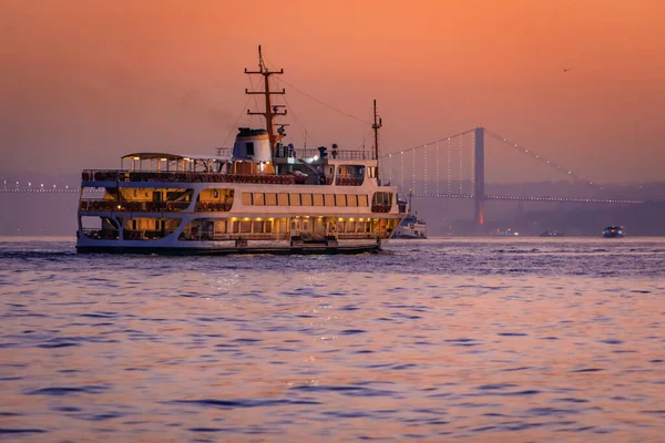 İstanbul, Türkiye 'deki İstanbul Boğazı' nın manzaralı manzarası ve İstanbul 'daki Boğaz Köprüsü' ne giden feribot gün doğumunun altın saatinde