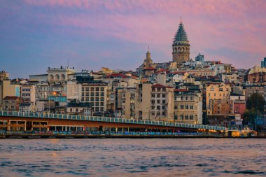 İstanbul, Türkiye 'de güneşin altın saatinde Galata Kulesi ile birlikte Galata Köprüsü' nün yanındaki İstanbul Boğazı 'nın karşısındaki Karaköy bölgesinin gündoğumu şehri.