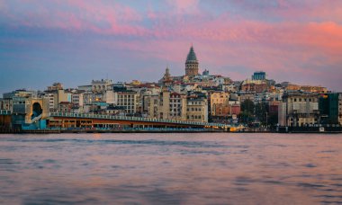 İstanbul, Türkiye 'de güneşin altın saatinde Galata Kulesi ile birlikte Galata Köprüsü' nün yanındaki İstanbul Boğazı 'nın karşısındaki Karaköy bölgesinin gündoğumu şehri.
