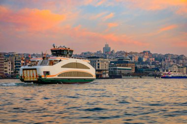 İstanbul, Türkiye 'de gün doğumunun altın saatinde İstanbul Boğazı' nın karşısındaki Galata Limanı 'ndaki Karaköy bölgesinin feribot ve gün doğumu manzarası
