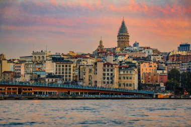 İstanbul, Türkiye 'de güneşin altın saatinde Galata Kulesi ile birlikte Galata Köprüsü' nün yanındaki İstanbul Boğazı 'nın karşısındaki Karaköy bölgesinin gündoğumu şehri.