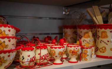Kaysersberg, France - June 2 2023: Ceramic mugs with traditional Alsatian designs, gingerbread man and pretzels on display at a souvenir store clipart