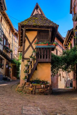 Fransa 'nın Eguisheim kentindeki Alsatian Şarap Yolu' nun popüler bir köyünde çiçeklerle süslenmiş geleneksel yarı ahşap evler.