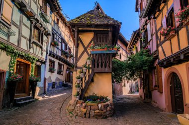 Fransa 'nın Eguisheim kentindeki Alsatian Şarap Yolu' nun popüler bir köyünde çiçeklerle süslenmiş geleneksel yarı ahşap evler.
