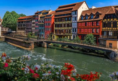 Strasbourg, Alsace, Fransa 'nın pitoresk Fransa bölgesindeki kanallar boyunca çiçeklerle süslenmiş geleneksel yarı ahşap evler.