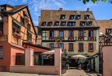 Gün batımında Fransa 'nın Colmar, Alsace bölgesindeki çiçeklerle süslenmiş geleneksel yarı ahşap evler.