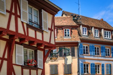 Ornate traditional half timbered houses with blooming flowers along the canals, Little Venice district in Colmar, picturesque village in Alsace France clipart