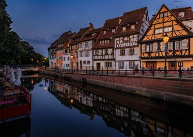 Kanallar boyunca çiçek açan yarım ahşap evler, Colmar 'daki Küçük Venedik bölgesi, gün batımında Fransa' nın Alsace kasabasının pitoresk köyü.