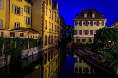 Kanallar boyunca çiçek açan yarım ahşap evler, Colmar 'daki Küçük Venedik bölgesi, gün batımında Fransa' nın Alsace kasabasının pitoresk köyü.
