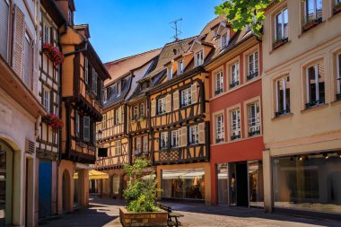 Ornate traditional half timbered houses with blooming flowers along the canals, Little Venice district in Colmar, picturesque village in Alsace France clipart